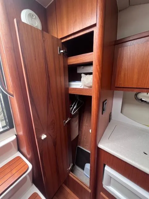 Slide: The Image of 2001 Tiara Yachts 3500 Express interior with wooden cabinetry and storage. - 15