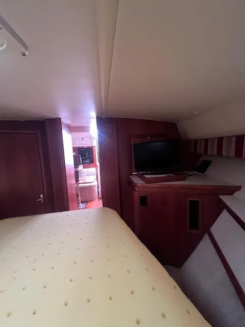 Slide: The Image of Interior of 2001 Tiara Yachts 3500 Express, featuring cozy cabin with TV and bed. - 20