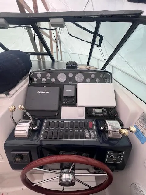 Slide: The Image of 2001 Tiara Yachts 3500 Express helm with navigation controls and steering wheel. - 24