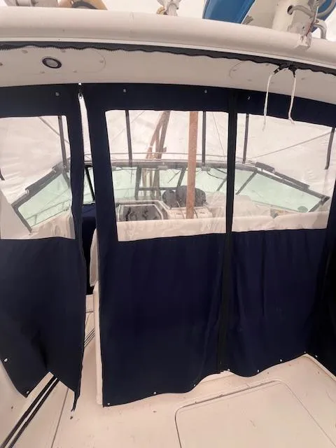 Slide: The Image of 2001 Tiara Yachts 3500 Express with navy blue cockpit enclosure. - 26