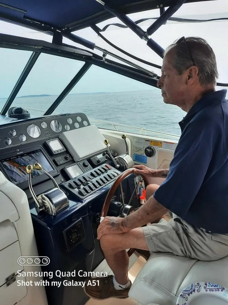 Slide: The Image of Man steering 2001 Tiara Yachts 3500 Express on open water. - 3