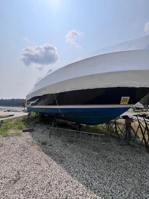 Slide: The Image of 2001 Tiara Yachts 3500 Express boat on land, covered, with clear sky background. - 31
