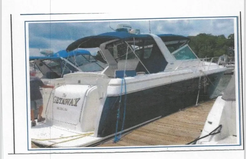 Slide: The Image of 2001 Tiara Yachts 3500 Express docked, featuring sleek design and blue canopy. - 4