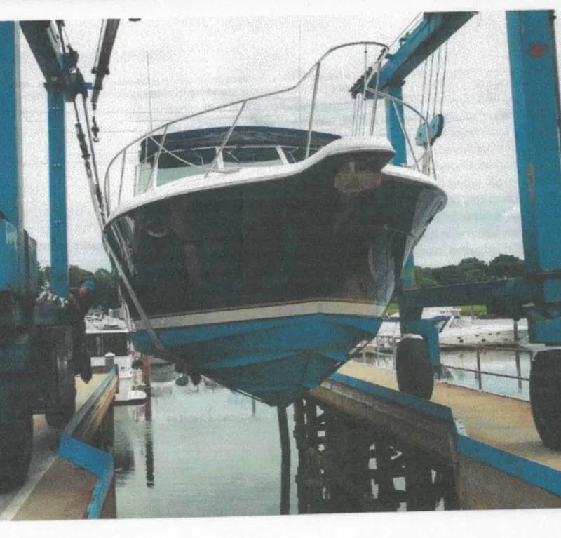 Slide: The Image of 2001 Tiara Yachts 3500 Express being lifted at a marina. - 5