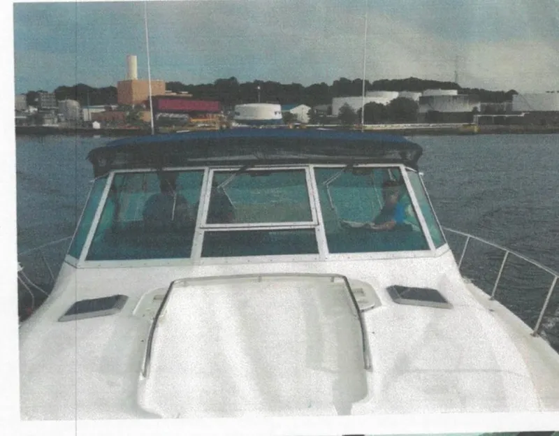 Slide: The Image of 2001 Tiara Yachts 3500 Express cruising near industrial waterfront. - 7