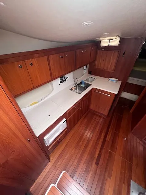 Slide: The Image of 2001 Tiara Yachts 3500 Express interior with wood cabinetry and flooring. - 9