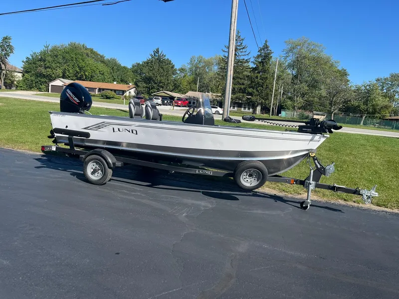 Slide: The Image of 2025 Lund 1600 Fury SS boat on trailer, parked outdoors on a sunny day. - 3