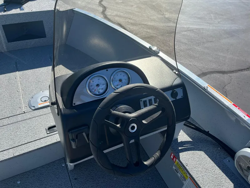 Slide: The Image of 2025 Lund 1600 Fury SS boat dashboard with steering wheel and gauges. - 9