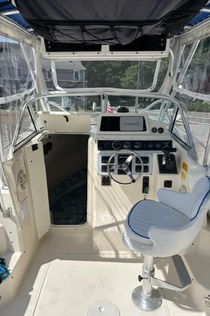 Slide: The Image of 2004 Key West 2300 WA boat cockpit with steering wheel and navigation equipment. - 10