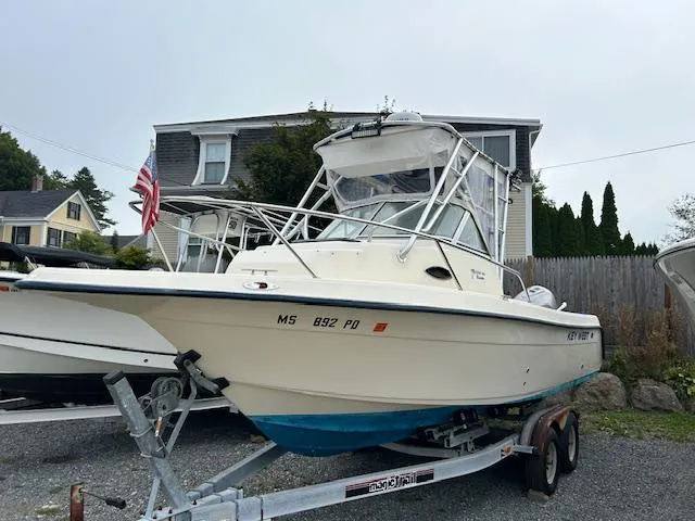Slide: The Image of 2004 Key West 2300 WA boat on trailer, parked outdoors near houses. - 12