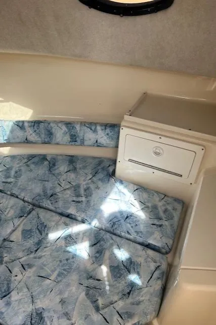 Slide: The Image of 2004 Key West 2300 WA cabin interior with patterned cushions and storage compartment. - 15