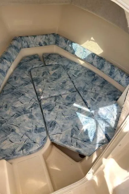 Slide: The Image of 2004 Key West 2300 WA cabin interior with blue patterned cushions. - 3