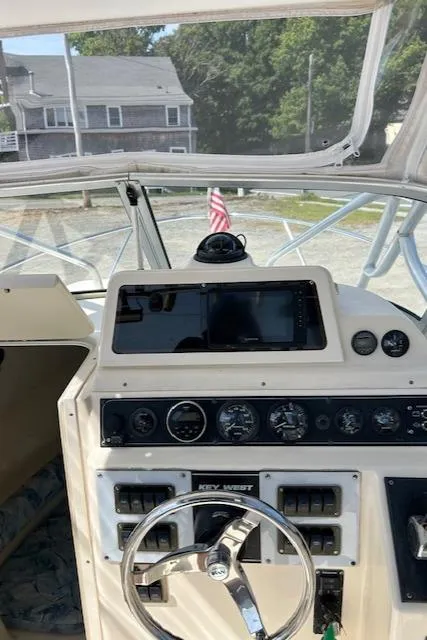 Slide: The Image of 2004 Key West 2300 WA boat dashboard with steering wheel and gauges. - 4