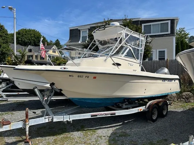 Slide: The Image of 2004 Key West 2300 WA boat on trailer, parked outdoors near houses. - 5