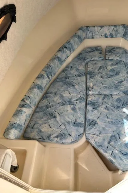Slide: The Image of 2004 Key West 2300 WA cabin interior with blue patterned cushions. - 8