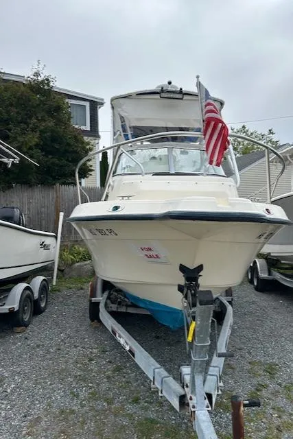 Slide: The Image of 2004 Key West 2300 WA boat on trailer with American flag, for sale sign visible. - 9