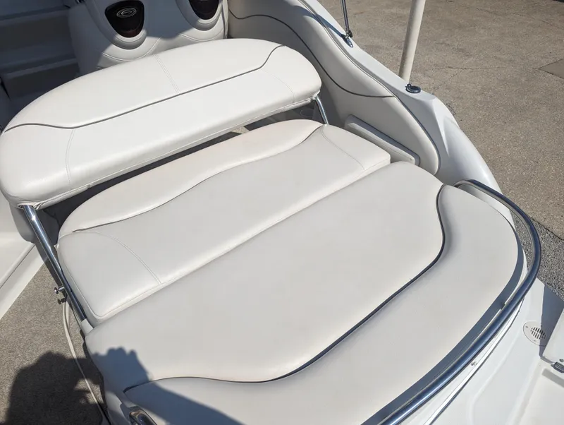 Slide: The Image of 2004 Crownline 250 CR boat interior with white cushioned seating. - 11