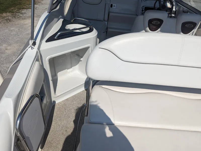 Slide: The Image of 2004 Crownline 250 CR boat interior with white seating and storage compartment. - 13