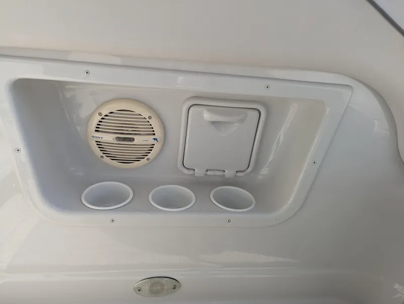Slide: The Image of 2004 Crownline 250 CR boat interior with speaker, storage, and cup holders. - 14