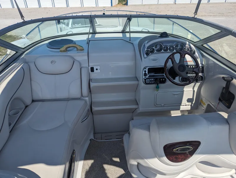 Slide: The Image of 2004 Crownline 250 CR boat interior with steering wheel and seating area. - 18