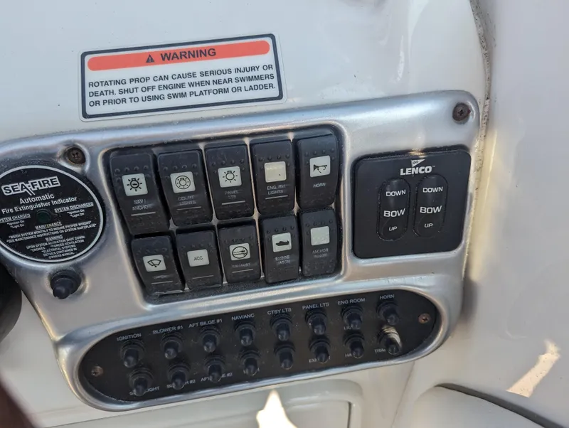 Slide: The Image of Control panel of a 2004 Crownline 250 CR boat with various switches and warning labels. - 21