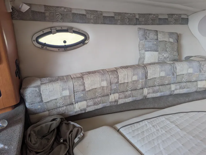 Slide: The Image of Interior cabin of 2004 Crownline 250 CR boat with patterned upholstery and porthole window. - 28