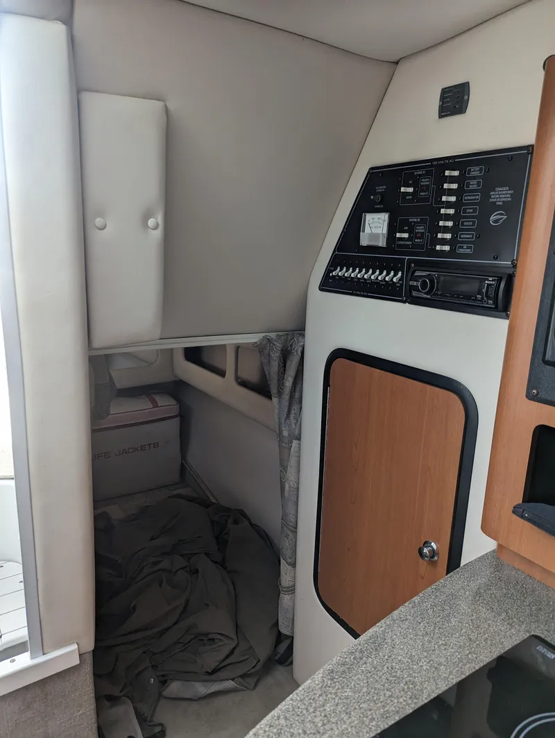 Slide: The Image of Interior of a 2004 Crownline 250 CR boat, featuring control panel and storage area. - 32