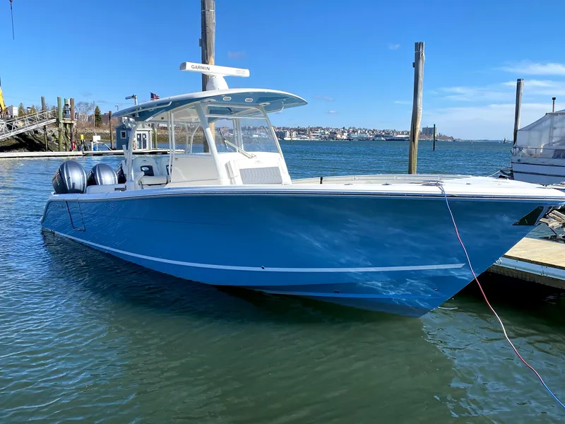 Slide: The Image of 2022 Cobia 350 boat docked in a marina, featuring a sleek blue hull. - 1