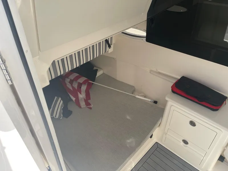 Slide: The Image of 2022 Cobia 350 cabin interior with bed, storage, and striped decor. - 11