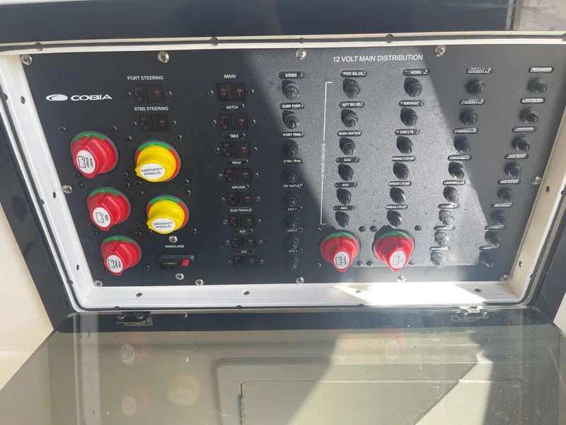 Slide: The Image of Control panel of a 2022 Cobia 350 boat with switches and indicators. - 13