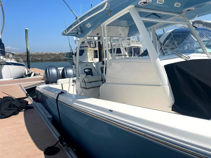 Slide: The Image of 2022 Cobia 350 boat docked, featuring sleek design and dual engines. - 4