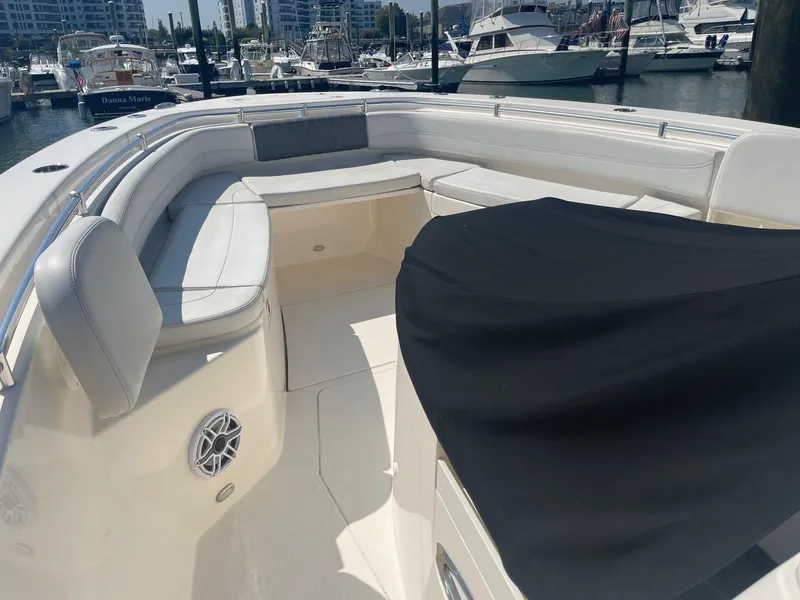 Slide: The Image of 2022 Cobia 350 boat interior with white seating at marina. - 6