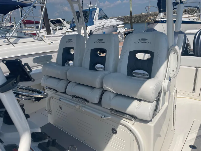 Slide: The Image of 2022 Cobia 350 boat with three cushioned seats at a marina. - 8