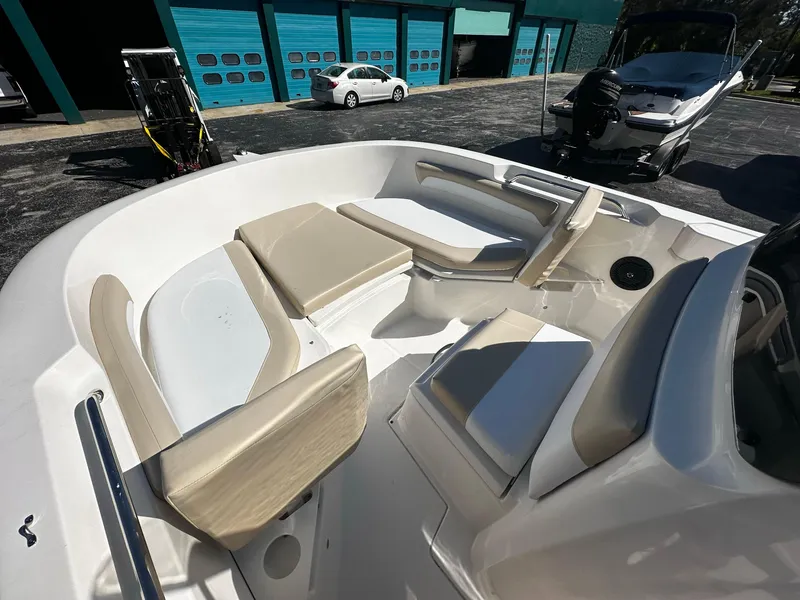 Slide: The Image of 2021 Trophy T20 boat interior with beige seating, parked near blue garage doors. - 3