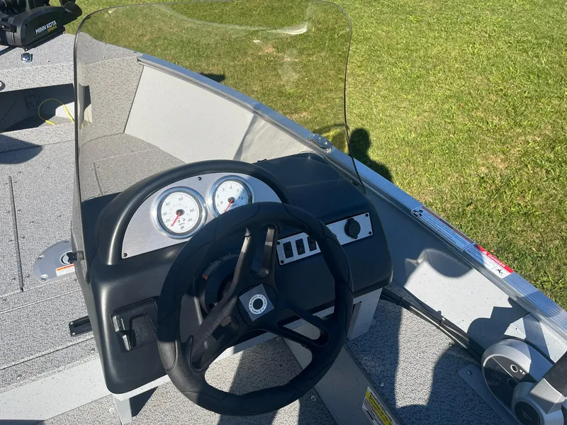 Slide: The Image of 2025 Lund 1600 Fury SS boat dashboard with steering wheel and gauges. - 11