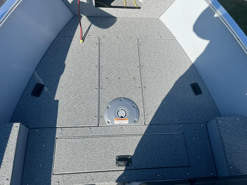 Slide: The Image of 2025 Lund 1600 Fury SS boat interior with gray carpeted deck. - 13