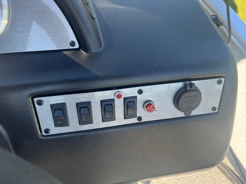 Slide: The Image of Control panel of 2025 Lund 1600 Fury SS boat with switches and power outlet. - 23