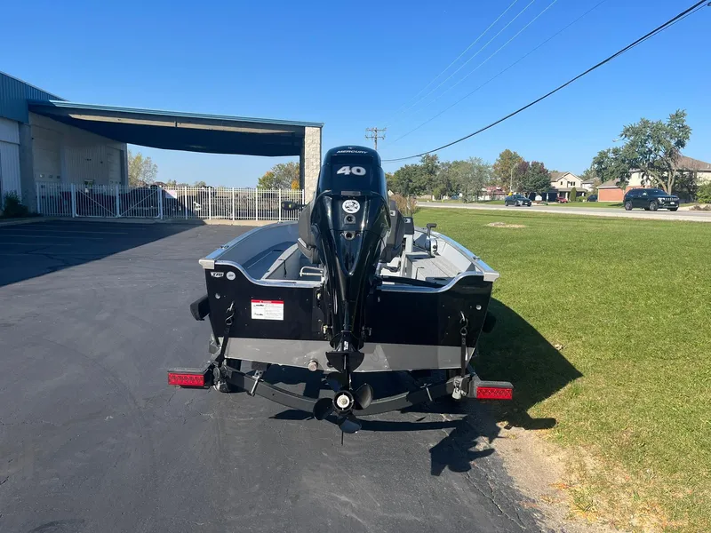 Slide: The Image of 2025 Lund 1600 Fury SS boat with 40 HP motor, parked outdoors. - 3