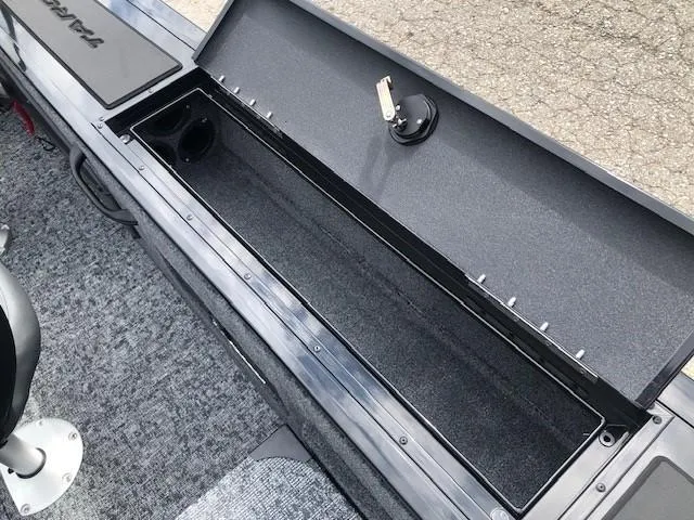 Slide: The Image of 2025 Tracker Targa V18 Combo boat storage compartment, open and empty, with carpeted interior. - 19