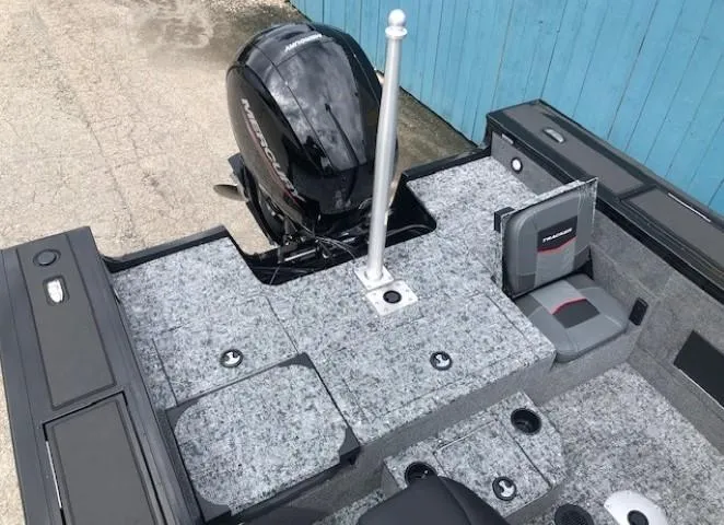 Slide: The Image of 2025 Tracker Targa V18 Combo boat interior with motor and seating, featuring gray carpeting. - 28