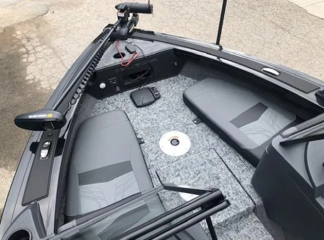 Slide: The Image of 2025 Tracker Targa V18 Combo boat interior with gray seating and fishing equipment. - 5