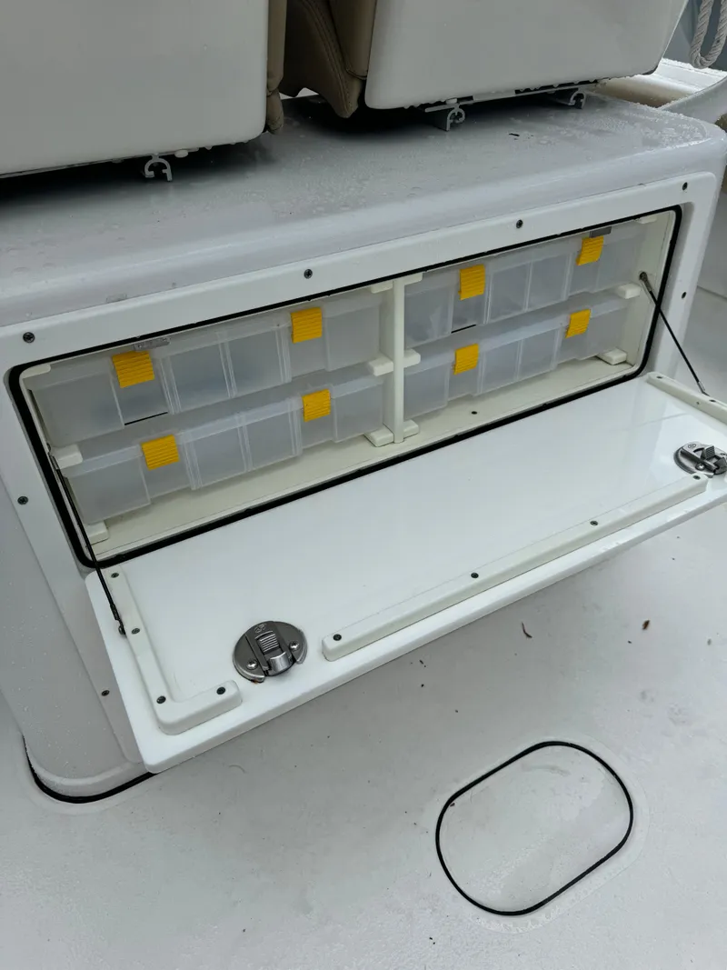 Slide: The Image of 2017 Sportsman Masters 267 Bay Boat tackle storage compartment with organized plastic boxes. - 15