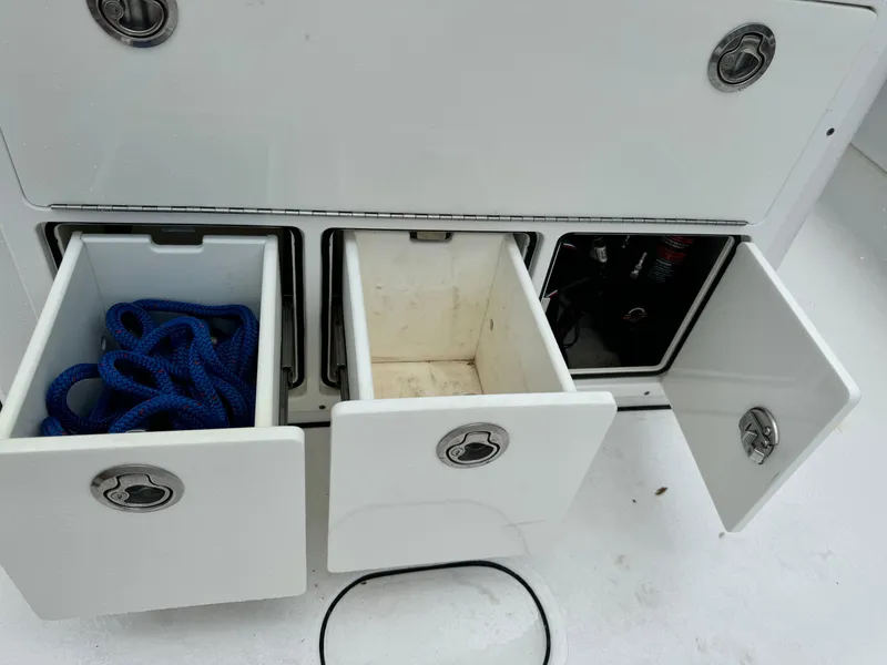 Slide: The Image of Storage compartments on a 2017 Sportsman Masters 267 Bay Boat with rope and open drawers. - 16