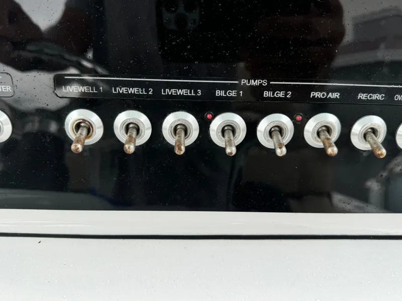 Slide: The Image of Control panel of a 2017 Sportsman Masters 267 Bay Boat with toggle switches for pumps. - 26