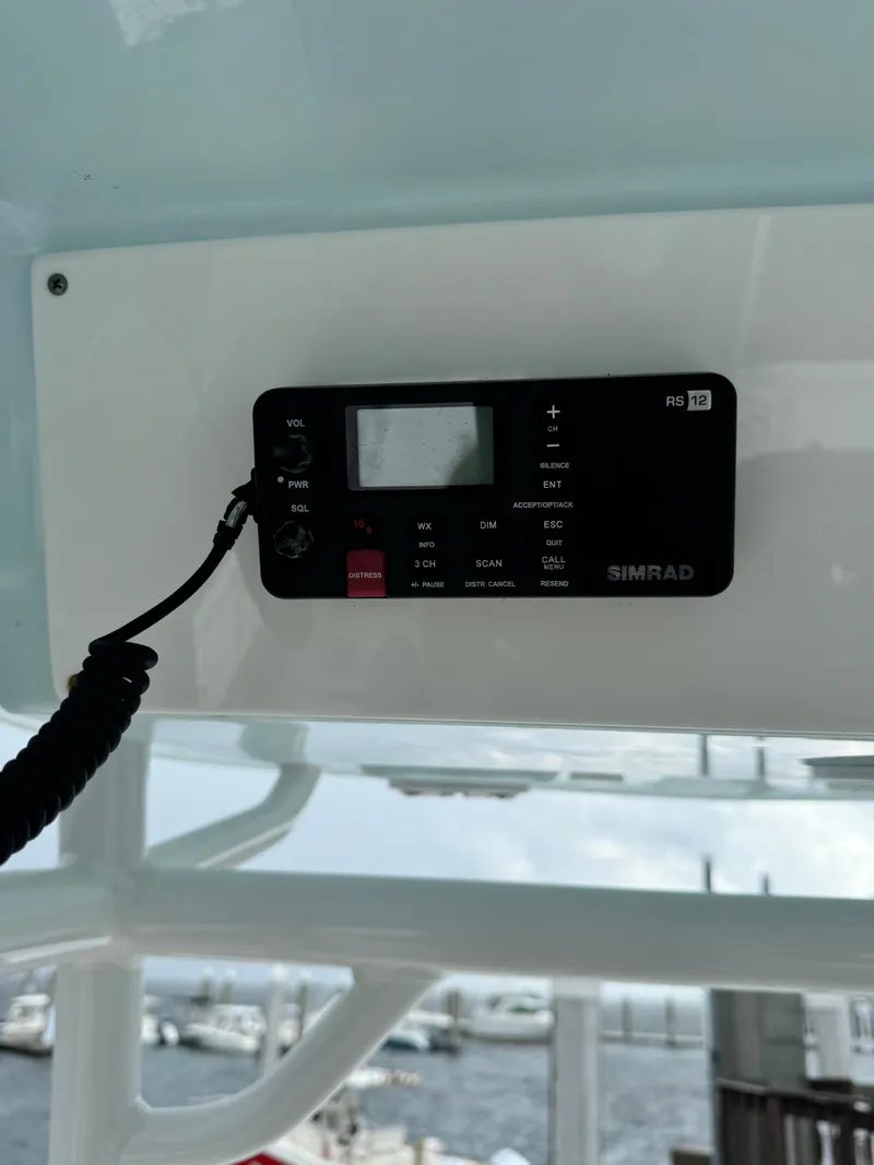 Slide: The Image of Simrad radio on 2017 Sportsman Masters 267 Bay Boat, docked with marina view. - 31