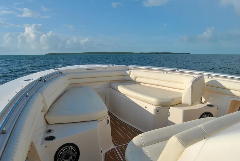 Slide: The Image of 2018 Grady-White Canyon 376 boat interior with cushioned seating, ocean view, and clear sky. - 24