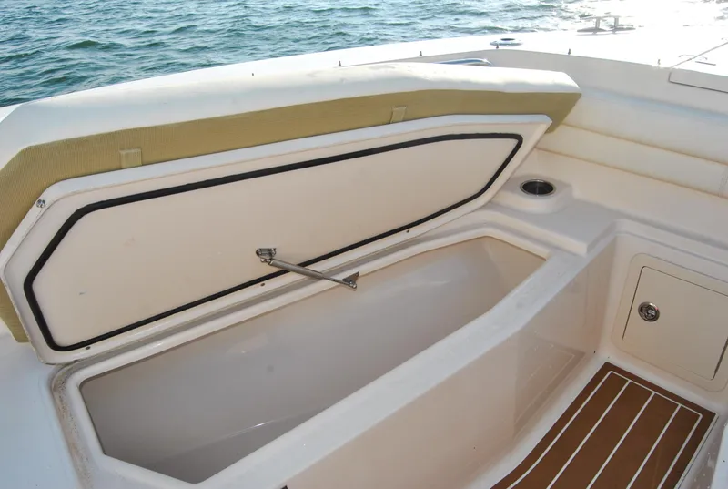 Slide: The Image of 2018 Grady-White Canyon 376 boat storage compartment open by the sea. - 25