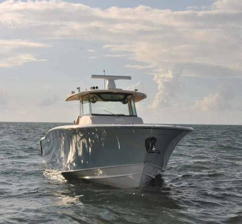 Slide: The Image of 2018 Grady-White Canyon 376 boat on open water under cloudy sky. - 44