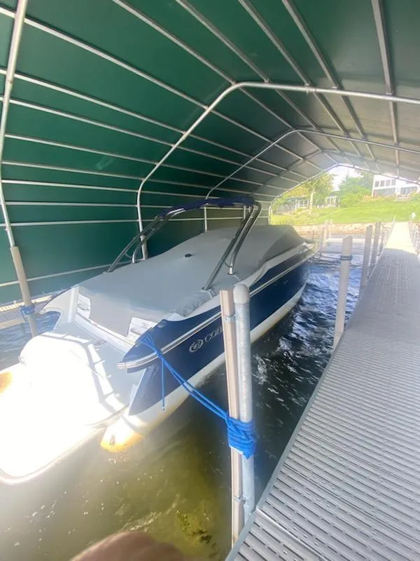 Slide: The Image of 2005 Cobalt 282 boat docked under a green canopy. - 3