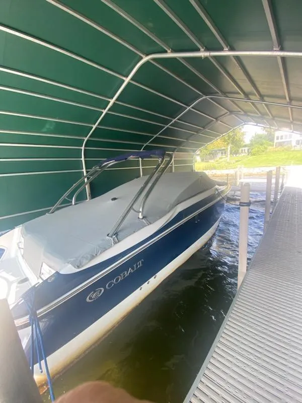 Slide: The Image of 2005 Cobalt 282 boat under a green canopy on a dock. - 4